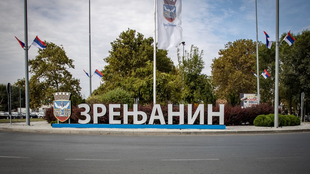 Entrance sign to Zrenjanin with Serbian flags and emblem, representing local patriotism.